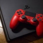 PS4 com controle Dualshock 4 sobre ele.