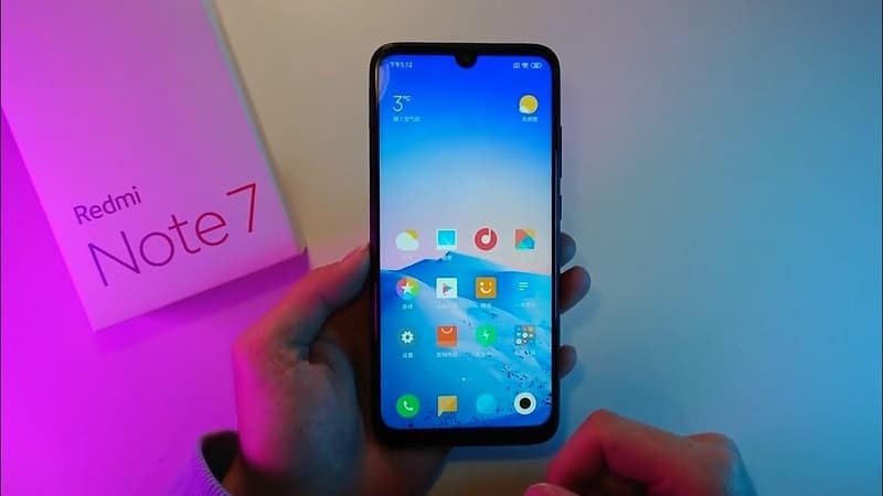 Redmi Note 7 recebe pacote de segurança de novembro de 2019 Redmi Note 7 sendo segurado com a tela ligada perto de sua caixa.