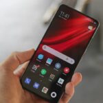 MI 9 Pro 5G com a tela ligada sendo segurado por uma mão.