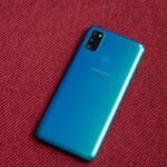 Galaxy M30s sobre uma superfície vermelha, com a traseira virada para cima.