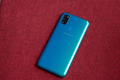 Galaxy M30s sobre uma superfície vermelha, com a traseira virada para cima.