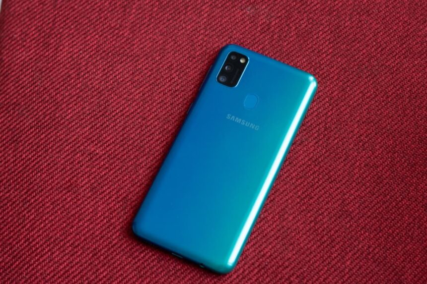 Galaxy M30s sobre uma superfície vermelha, com a traseira virada para cima.