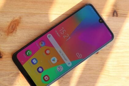 Galaxy M30 com a tela ligada, sobre uma superfície de madeira.