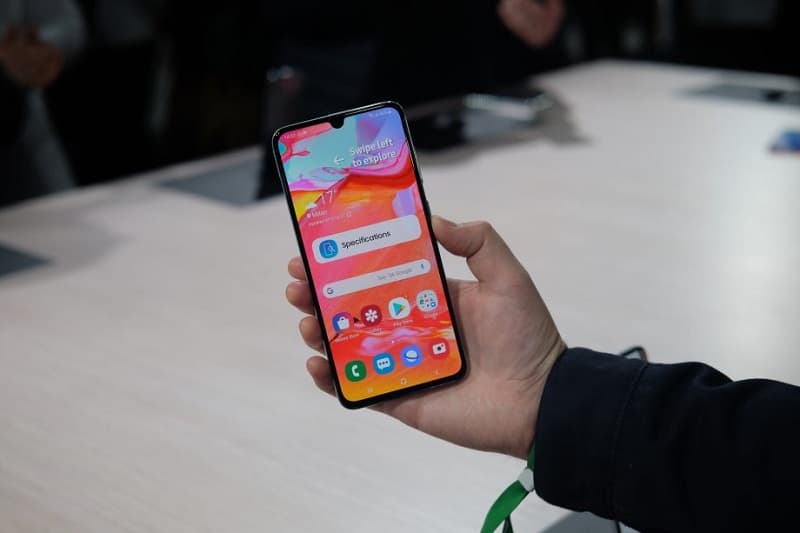 Samsung Galaxy A70 sendo segurado com a tela ligada.