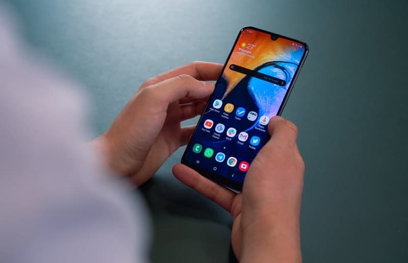 Galaxy A50s começa a ser atualizado para o Android 10 Galaxy A50s com a tela ligada sendo segurado em duas mãos.