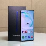 Samsung Galaxy Note 10 Lite ao lado da caixa.