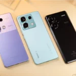 Foto ilustrativa com três smartphones Xiaomi lado a lado com a parte traseira virada para cima.