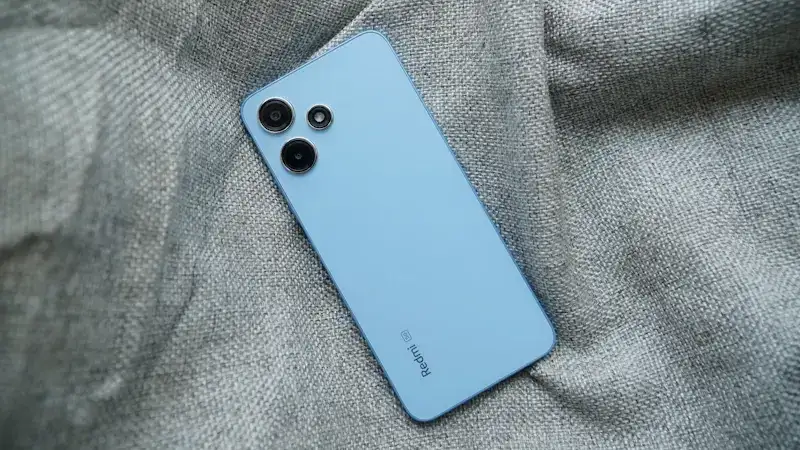Redmi 12 é um celular bom e barato por menos de R$ 800 Redmi 12 5G, traseira, smartphone apoiado num tecido.