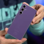 Mãos segurando o Galaxy S23 FE roxo