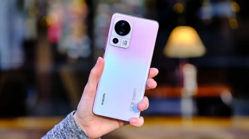 Xiaomi 13 Lite rosa sendo segurado.
