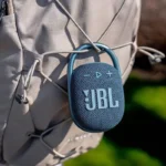 Imagem da JBL Clip 4 Eco pendurada em uma mochila.